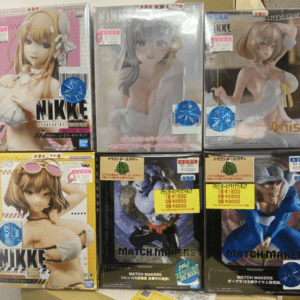 Six boxed anime figures on a store shelf, featuring female characters in swimwear and white outfits with sale stickers and blue holographic seals.