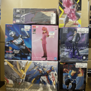 Stack of boxed anime action figures on a store shelf, including Gundam Wing and Ultraman boxes.
