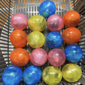 Colorful translucent plastic balls arranged in a gray basket.