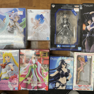 assortment of anime figurine boxes on a wooden table, featuring Sailor Moon, Relanime, Overlord, and Neongenesis Evangelion figures in colorful packaging  Articulos Japan (Post Box Japan)