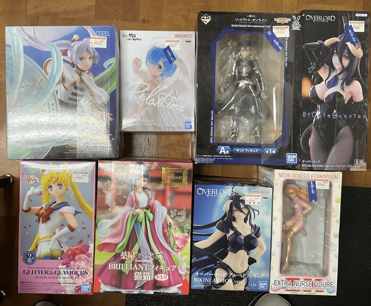 Ver Fotos Recientes 98 - Articulos Japan (post Box Japan) assortment of anime figurine boxes on a wooden table, featuring Sailor Moon, Relanime, Overlord, and Neongenesis Evangelion figures in colorful packaging Articulos Japan (Post Box Japan)