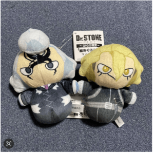 Two Dr. Stone character plushies in gray outfits lying together on a blue fabric, with a tag visible between them