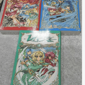Three colorful manga volumes with ornate gold borders and anime-style characters on the covers: red, blue, and green editions labeled 'CLAMP'.  Articulos Japan (Post Box Japan)