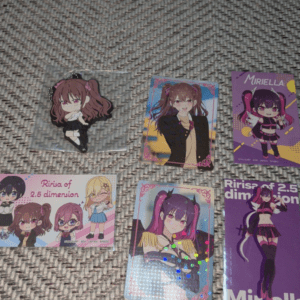 Six anime character cards laid on a textured gray carpet, colorful and cute chibi-style figures.