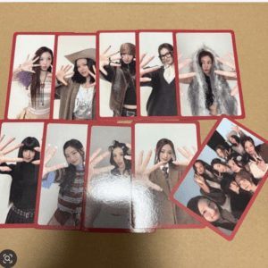 A collage of glossy photo cards showing a girl group posing with hands raised, arranged in red-framed panels on a brown background.
