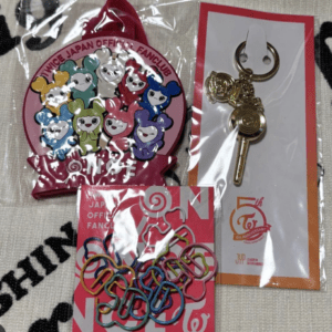 Pink circular TWICE Japan Official Fanclub badge with colorful cartoon bears and a pink lanyard.