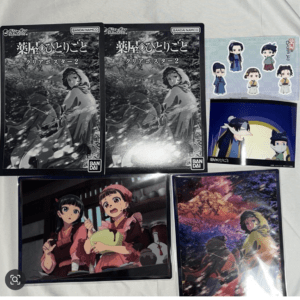 Collection of anime merchandise: two boxed clear posters with Bandai Namco logo, plus a chibi sticker sheet and two art prints featuring anime characters.  Articulos Japan (Post Box Japan)