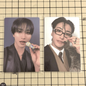 Two glossy photo cards of a young man: left card shows him with black hair blowing bubbles from a small wand; right card shows him wearing glasses, a suit, and a fur-trimmed coat posing with a finger ring.