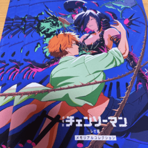 Chainsaw Man memory collection cover: orange-haired man embraces a woman as neon tentacles swirl on a blue background with Japanese text at the bottom.  Articulos Japan (Post Box Japan)