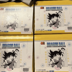 Four yellow Dragon Ball boxes with black-and-white Goku illustrations and blue Dragon Ball logo on the front shelf.