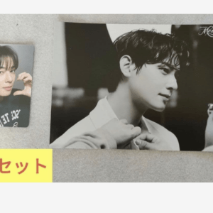 Black-and-white poster of a man being adjusted by someone, with a small photo card of a young man making a heart gesture beside it, and a yellow label reading '×5セット' indicating five sets.
