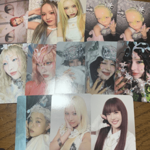Collage of glossy portraits of young women in vibrant costumes laid on a wooden table.