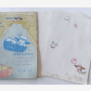 Blue notebook cover with rabbits in a boat and the title Tiny Candy beside a pale river scene.