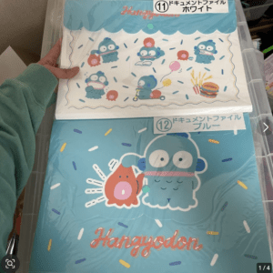 Hangyodon-themed stationery set with a blue blobby character and confetti on turquoise packaging, 'Hangyodon' text visible at bottom on a folder.
