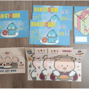 Set of blue Han-gy-don envelopes with a blue monster, small red creature, and palm tree drawings on a wooden surface.