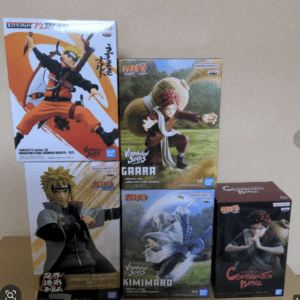 Stack of Naruto action figure boxes on a table, featuring Naruto, Gaara, and Kimimaro figures from the Vibrations Stars line.