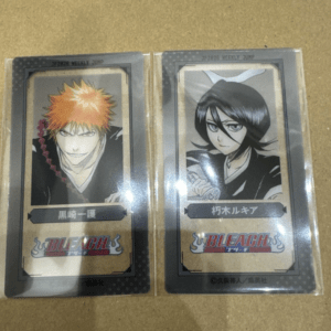 Two Bleach trading cards in plastic sleeves, featuring Ichigo Kurosaki (left) and Kisuke Urahara (right).