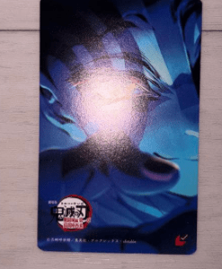 Blue abstract poster/card with swirling shapes and a white‑red sticker near the bottom left, resting on a light wooden surface.