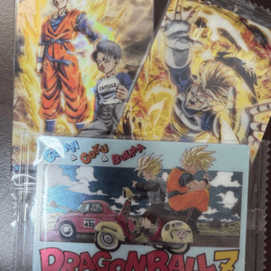 Dragon Ball Z-themed merchandise: a glossy packet with Goku in orange gi standing beside another character, plus a separate bag showing action scenes and a bright logo in the background of fiery colors.  Articulos Japan (Post Box Japan)