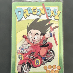 Dragon Ball trading card showing Goku riding a red motorcycle with the 'DRAGON BALL' logo above and a green background behind him.