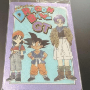 Package of Dragon Ball GT merchandise; purple cover with three characters (girl with orange hair, Goku in orange outfit, tall boy with purple hair) on a light blue background, sealed in plastic.  Articulos Japan (Post Box Japan)