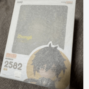Box packaging for a collectible figure, featuring a black-haired anime character inside a yellow circle.