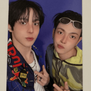 Two young men posing for a photo, one with black hair in a blue jacket and the other wearing sunglasses and a lime camo jacket, against a purple background.