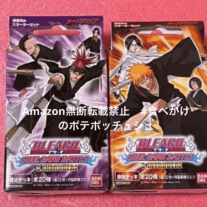 Two Bleach trading card game booster packs with dynamic anime character art on purple and orange packaging, placed on a pink carpet.