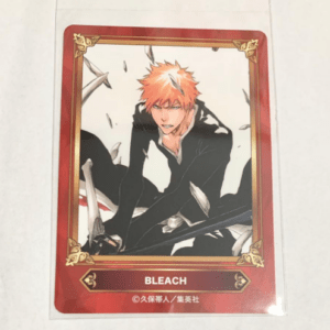 Bleach trading card showing Ichigo Kurosaki with orange hair in a black outfit, framed by a red border with gold corners, BLEACH text at bottom.