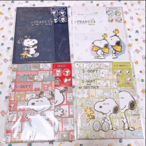 Set of four Peanuts notebook packs featuring Snoopy and Woodstock in navy, white, red, and green covers (plastic-wrapped)