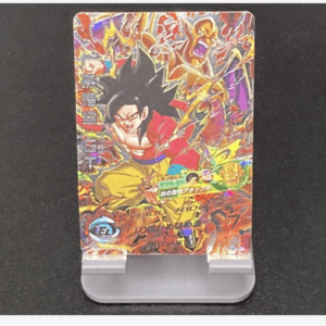 Colorful Dragon Ball trading card with Goku in a red jacket, mid-action, on a gray display stand with energy bursts around him.