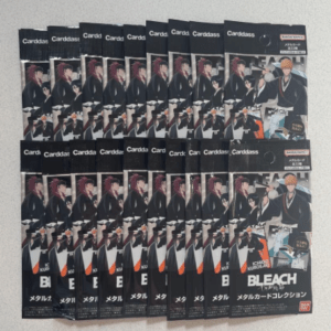 Row of Bleach Carddass trading card packs laid out on a surface, showing black packaging with anime character art and the Bleach logo.