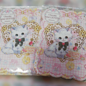Two pastel gift packs showing a white kitten with a black bow, lace circle, and floral background; text reads 'Chocoto mini LETTER' on each package.