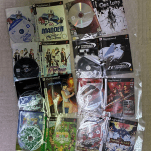 Collection of PlayStation 2 game cases and discs arranged on a light carpet, featuring Madden 2001 and Formula One 2001, all in plastic sleeves.