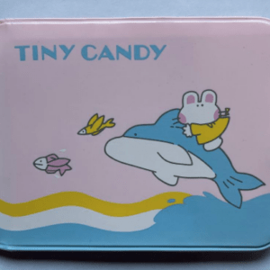 Pink candy tin with 'TINY CANDY' text, showing a blue shark carrying a white mouse in a yellow shirt and two small fish.