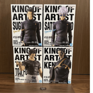 Four 'King of Artist' action figure boxes arranged in a 2x2 grid on a wooden surface, featuring Gojo, Sukuna, Itadori, and Kenjaku figures.