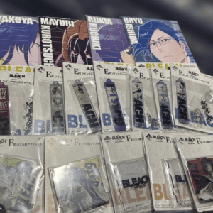 Display of Bleach posters featuring characters with packaged acrylic charms in front.