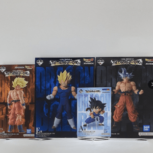 Row of Dragon Ball action figure boxes on a shelf, featuring Goku in various forms and a small blue-in-front box of Kid Goku.
