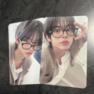 Two side-by-side selfies of a person with black hair and glasses, wearing a beige blazer and white shirt, on a rounded square photo card.
