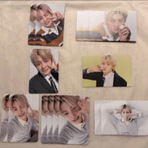 Collection of glossy photo cards featuring a blond-haired young man posing in various outfits on a beige surface.