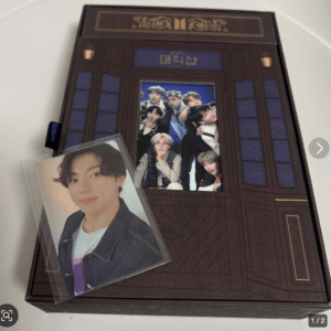 Brown door-themed photo box with a group poster visible inside, and a glossy portrait card of a young man resting on top.