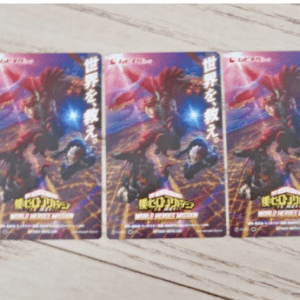 Three identical trading cards laid in a row on a light wooden surface, featuring a colorful action scene with heroes.