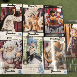 Boxed Grandista anime figures displayed on a metal rack, showing colorful character poses and packaging text