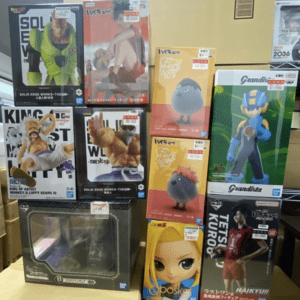 Display of boxed anime and video game figurines in colorful packaging on store shelves, arranged in a grid display.