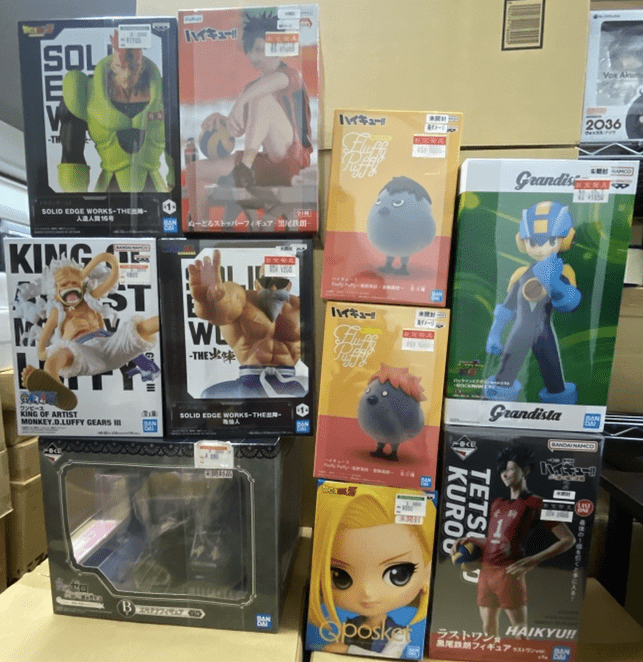 Captura De Pantalla 2026-06-01 a Las 180941 - Articulos Japan (post Box Japan) Display of boxed anime and video game figurines in colorful packaging on store shelves, arranged in a grid display. Articulos Japan (Post Box Japan)