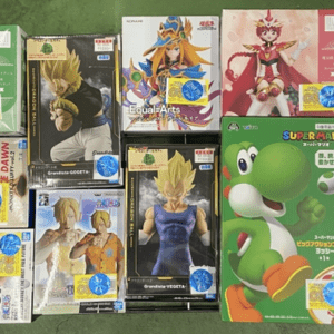 A wide assortment of boxed anime and video game figures laid out on a floor, featuring Dragon Ball characters, Super Mario Yoshi box, and various colorful collectible boxes stacked side by side.