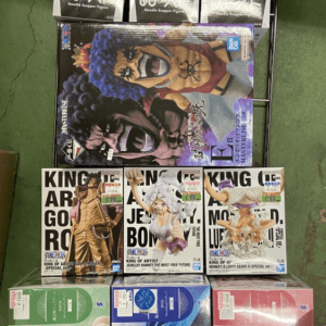 Display of boxed anime figures on a metal rack, including large colorful figures on the bottom and smaller boxes on top shelves.