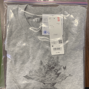 Gray UT T-shirt folded in a clear resealable bag, tag attached, graphic of a potted plant and butterfly on the front.