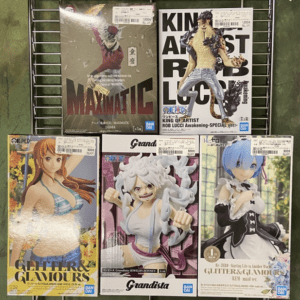 Shelf of six anime figure boxes on a metal rack, featuring Grandista white-haired character in the center and two Glitter & Glamour figures on the bottom row.