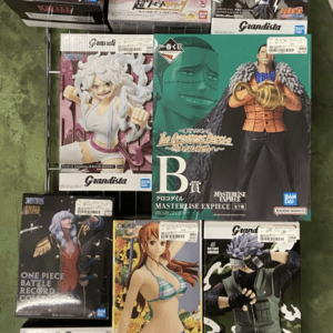 Display of various anime figurine boxes on a metal rack, showcasing different characters and brands.